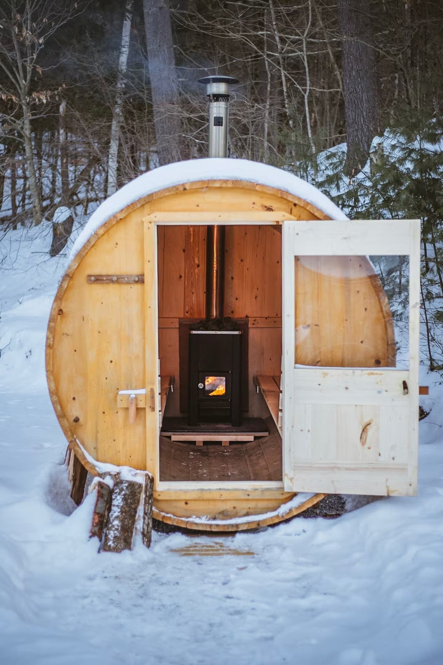 A wooden cabin with a fireplace, a door, and a window.