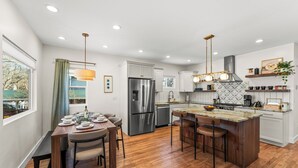 A modern kitchen with a central island, stainless steel appliances, and pendant lighting. - New- Encore Retreat- Sauna-Fire Pit- Theater Room (Colorado Springs)