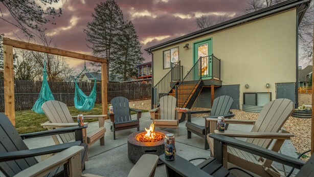 An outdoor patio area with Adirondack chairs, a fire pit, and a wooden pergola. - New- Encore Retreat- Sauna-Fire Pit- Theater Room (Colorado Springs)