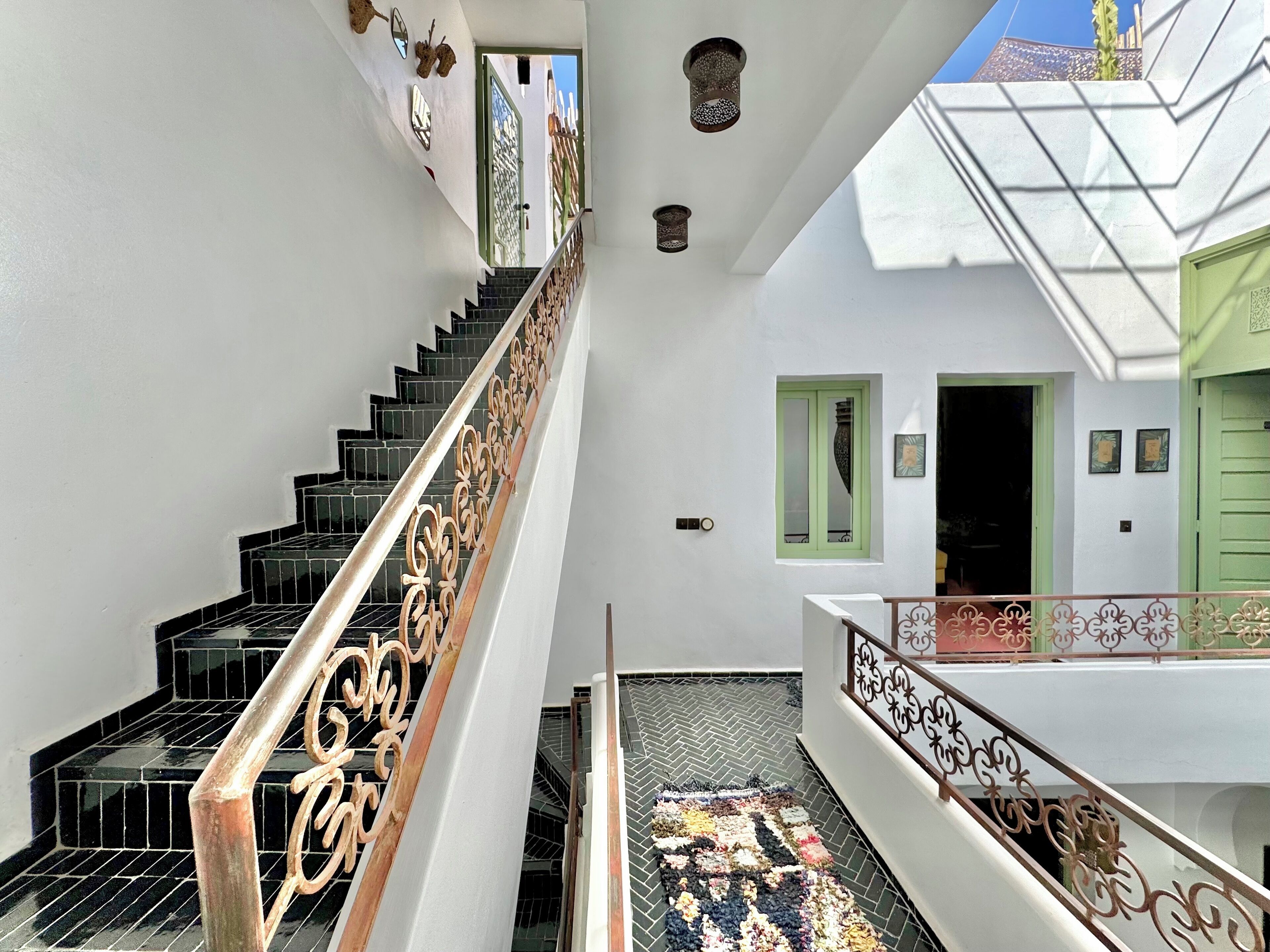A staircase with black tiled steps and ornate metal railings.