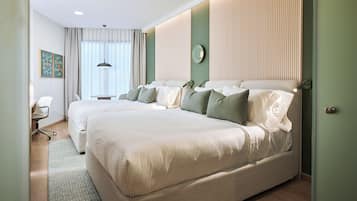 A hotel room with a large bed, a desk, and a chair.