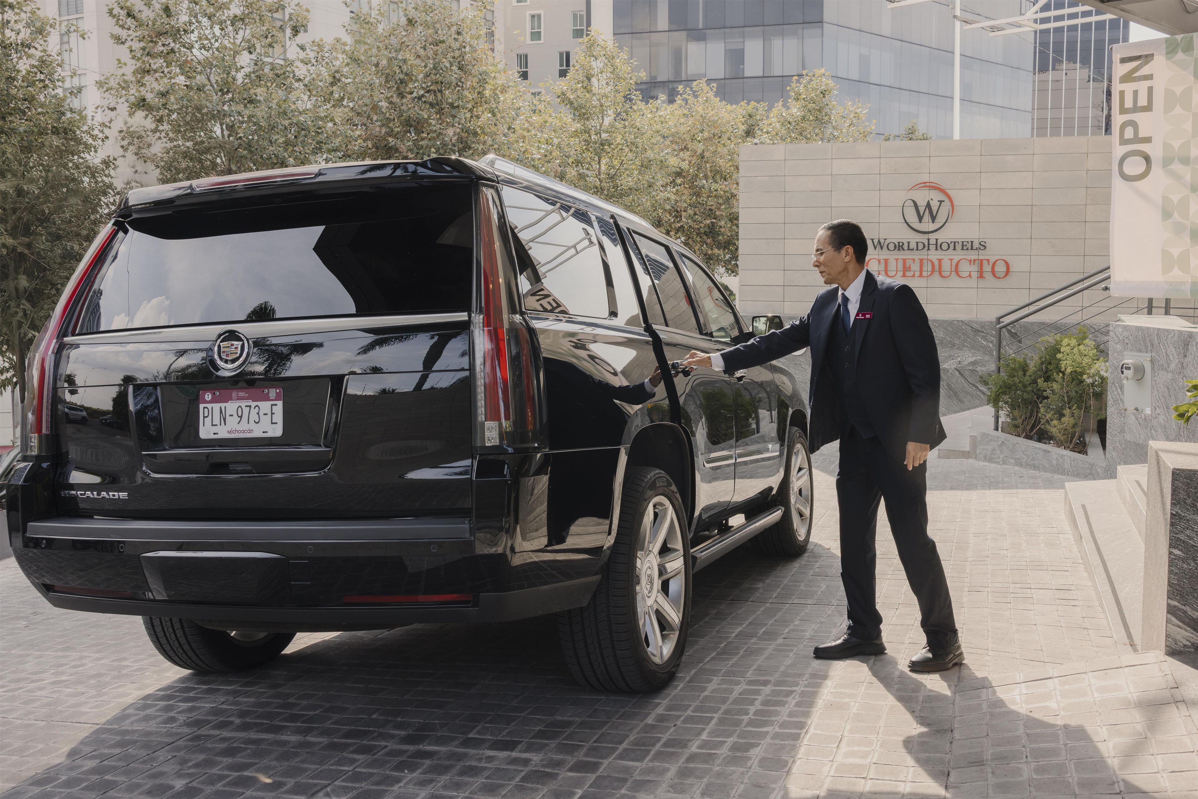 Um SUV preto estacionado em frente a um edifício com uma placa que diz 'WorldHotels CUEDUTO'.