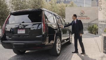 Um SUV preto estacionado em frente a um edifício com uma placa que diz 'WorldHotels CUEDUTO'.
