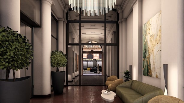 A modern hotel lobby with a central column, a reception desk, a green sofa, and a large abstract painting on the wall. - SOPHIA PALACE Hotel Budapest (Budapest)