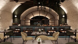 A restaurant with a brick wall arch, hanging plants, and a counter with food displays. Tables and chairs are arranged for dining. - SOPHIA PALACE Hotel Budapest (Budapest)