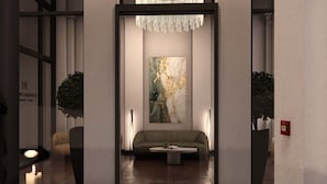 A modern lobby with a green sofa, a large abstract painting, and a unique light fixture. - SOPHIA PALACE Hotel Budapest (Budapest)