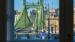 A view through a window of a green bridge with a dome and a building in the background. - SOPHIA PALACE Hotel Budapest (Budapest)