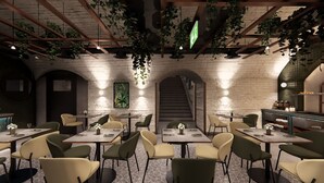 A restaurant with brick walls, hanging plants, and a staircase. Tables and chairs are arranged for dining. - SOPHIA PALACE Hotel Budapest (Budapest)