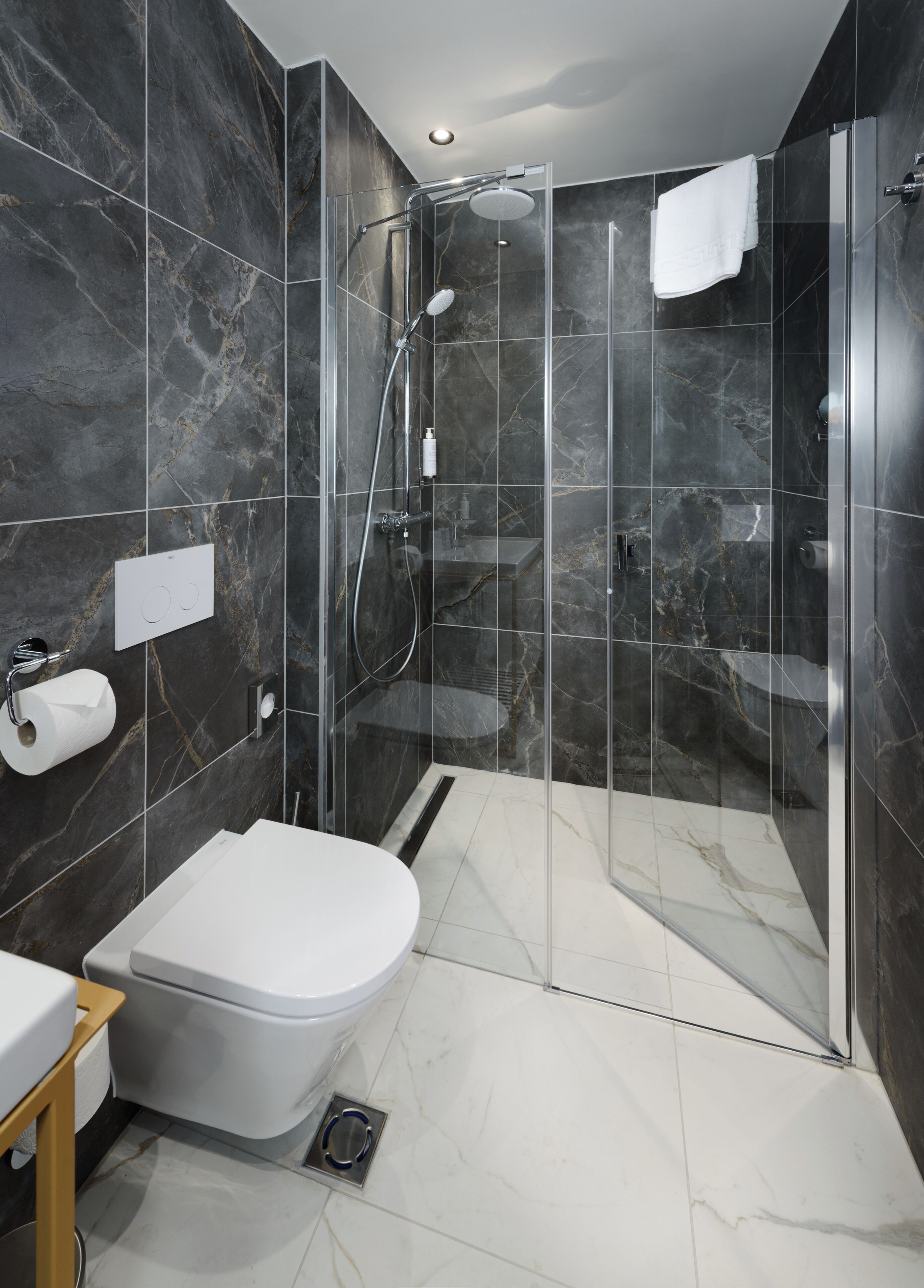 A modern bathroom with a toilet, shower, and sink.