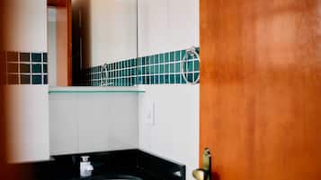 Chuveiro, toalhas de banho, sabonete, papel higiênico