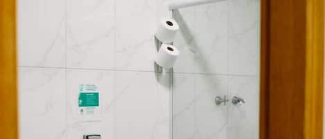 Chuveiro, toalhas de banho, sabonete, papel higiênico