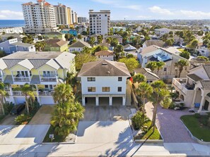 Zona residencial com diversos tipos de casas, incluindo uma casa branca notável com uma garagem em primeiro plano.