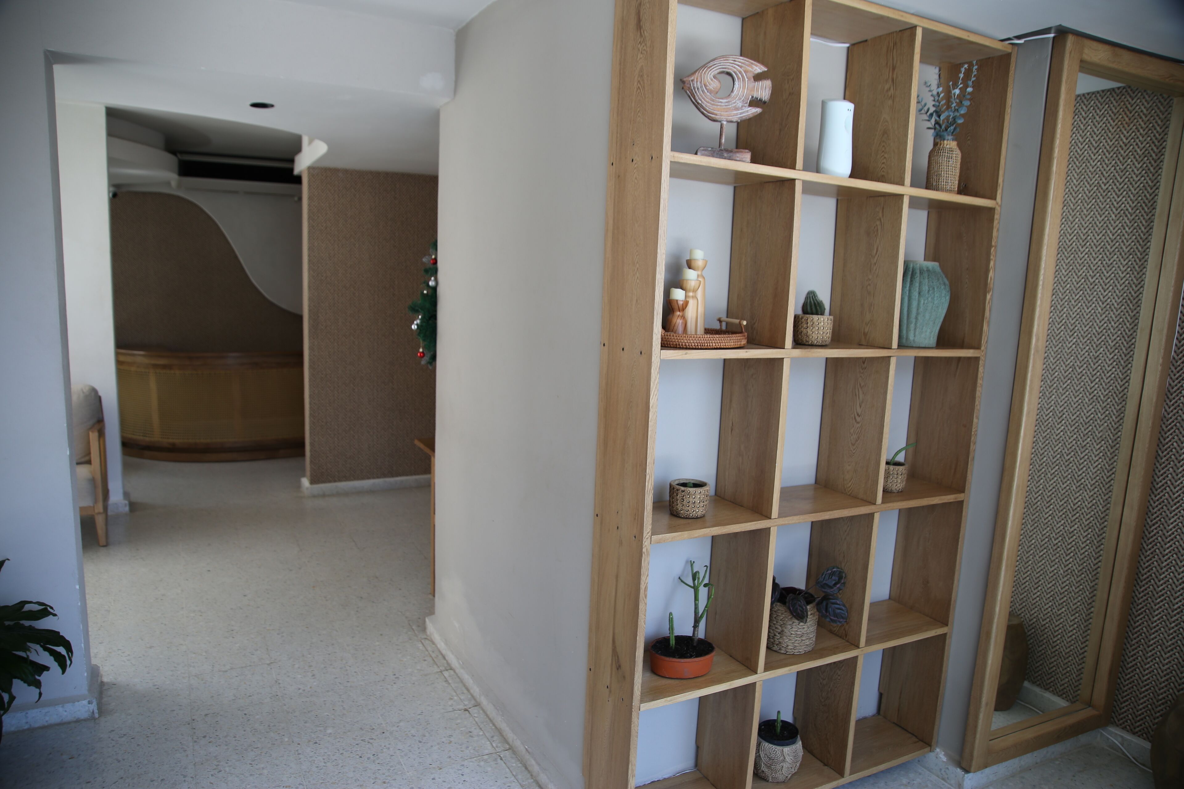 Un pasillo con un aparador de madera que contiene varios objetos decorativos.
