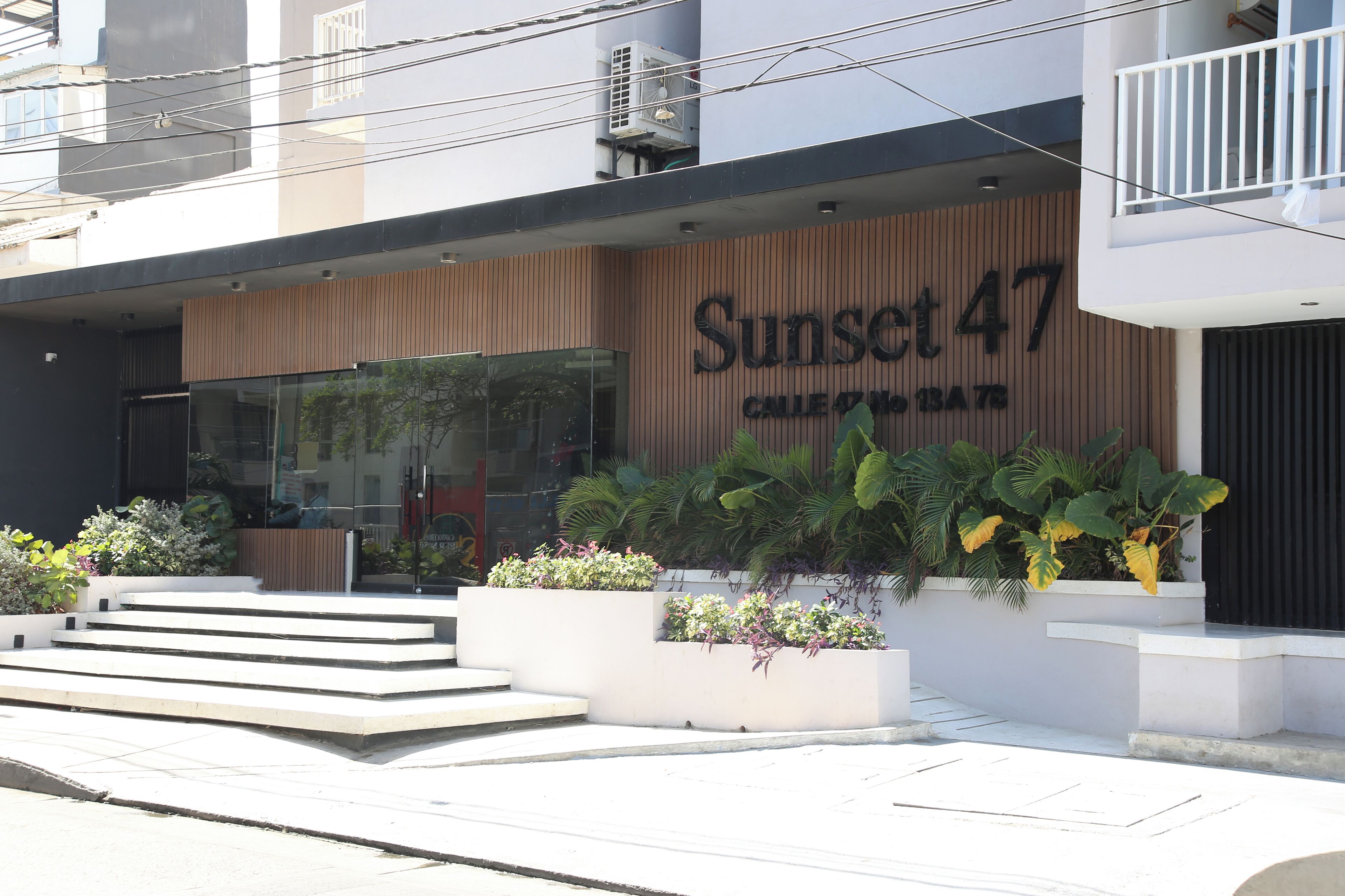 Un edificio con un letrero que dice "Sunset 47" y una escalera que lleva a la entrada.