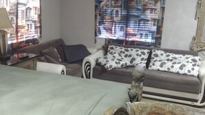 A living room with a sofa, a coffee table, and a patterned curtain. - Pleasant 1-bedroom house with AC in sunny Orlando (Orlando)