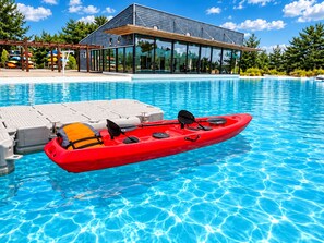 A modern building with a glass facade, a pool with kayaks, and a paddleboard area. - El mejor lugar con Laguna paradisíaca (Las Cruces)