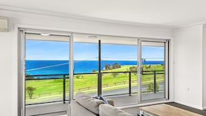 A balcony with a view of the ocean and a grassy area. - Golfers View Penthouse (Narooma)