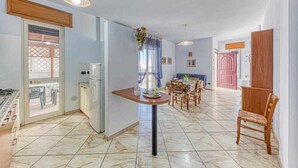 Una cuina àmplia amb zona de menjador, un frigorífic i un rentaplat.