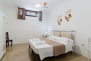 Een hotelkamer met een bed, een stoel, een nachtkastje met een lamp en een decoratie aan de muur.