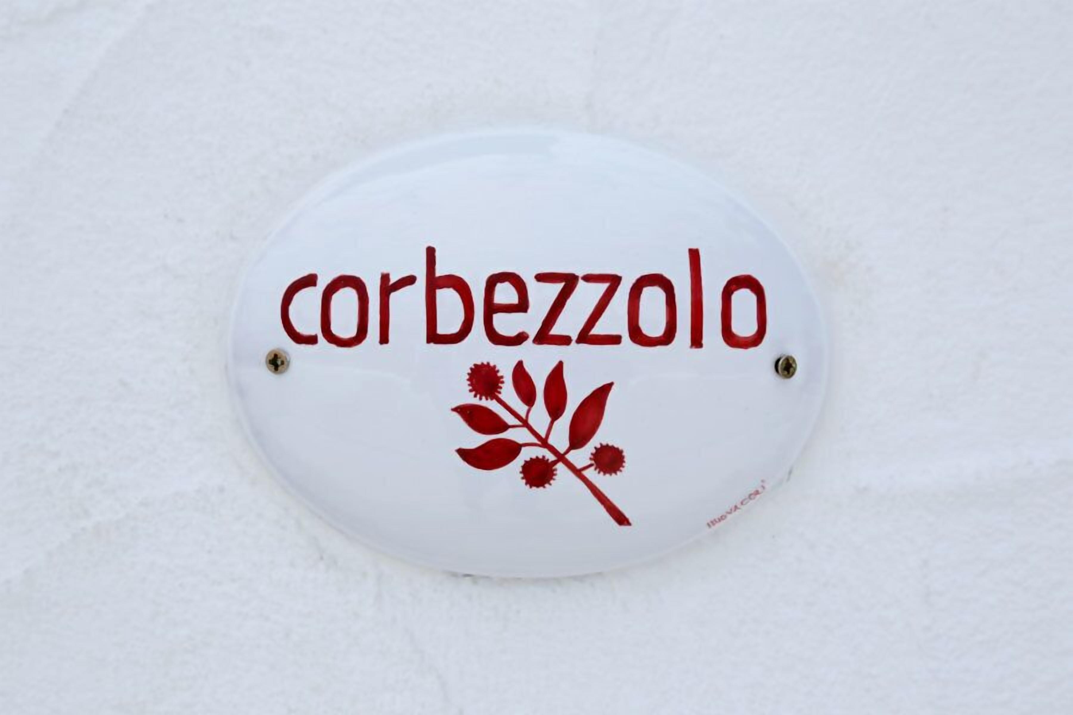 A white sign with the text "corbezzolo" and a red decorative element.