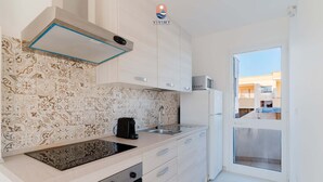 Et moderne køkken med et mønstret backsplash, indbygget ovn og en mikrobølgeovn på bordpladen.