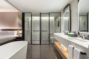 Un bagno moderno con una vasca da bagno ampia, una zona doccia separata e un mobile toilette con specchio.