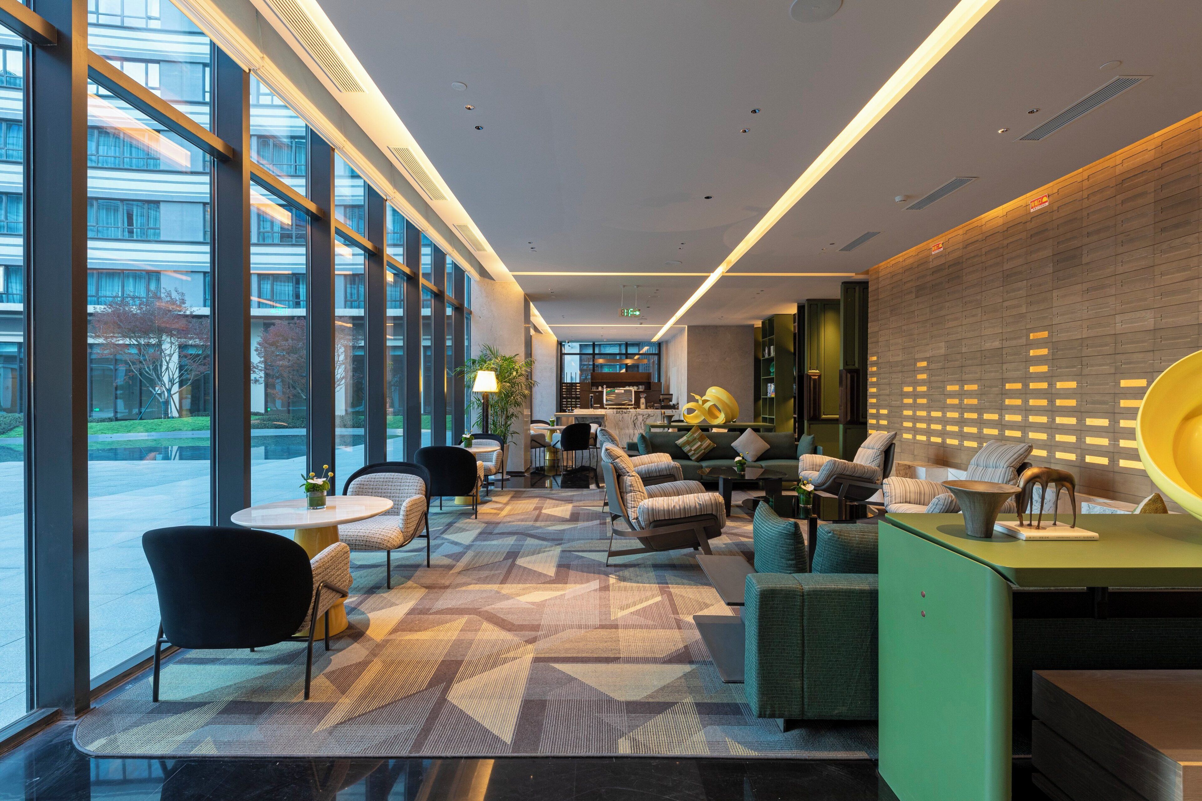 Una hall moderna con ampie finestre, zone relax e una reception.