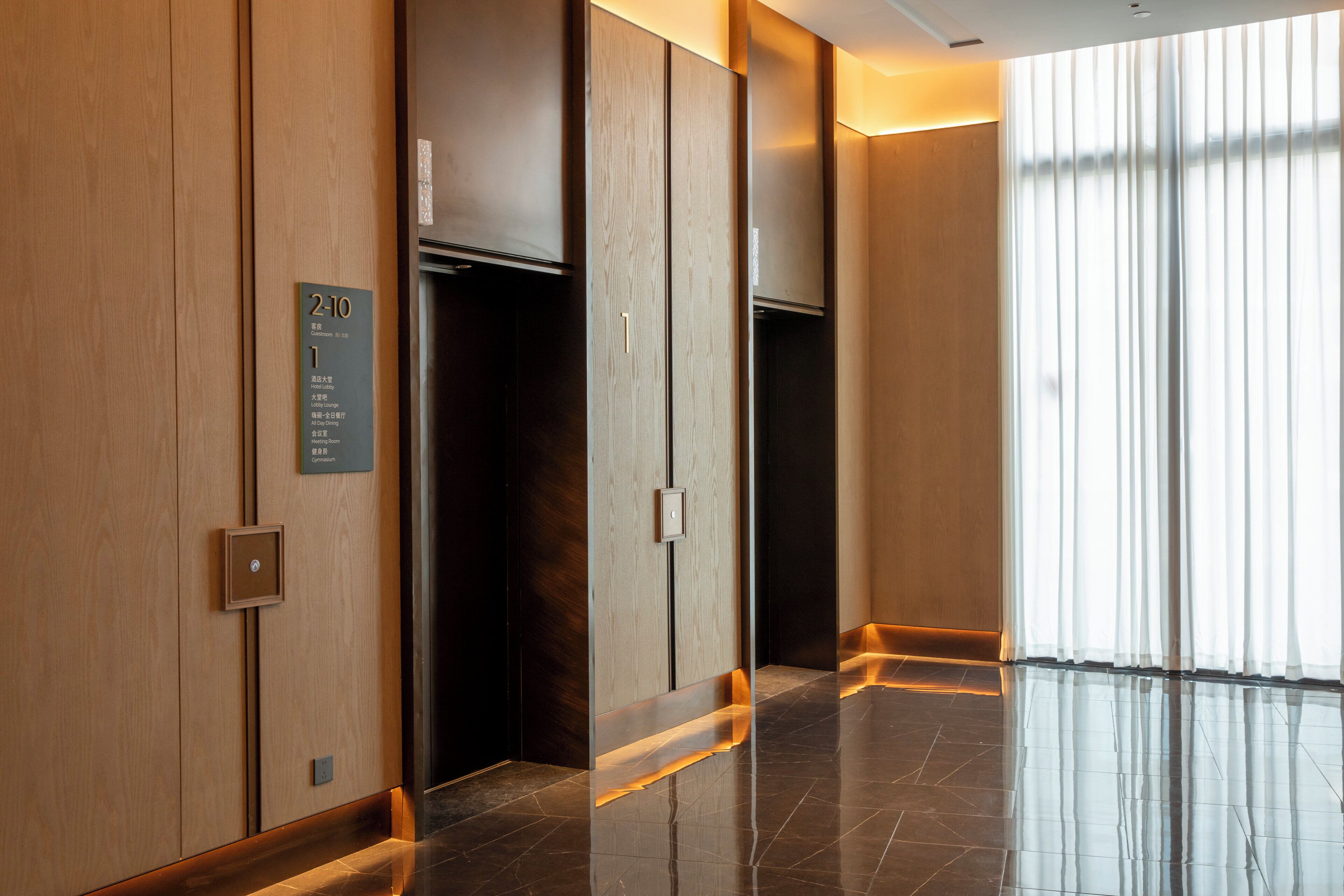 Een moderne lift met houten afwerking en een digitaal scherm.