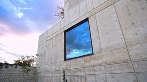 A modern building with a large window reflecting the sky. - Casa del Sol - CasaBlanca. Pool, privacy and mountain views (Oaxaca de Juárez)