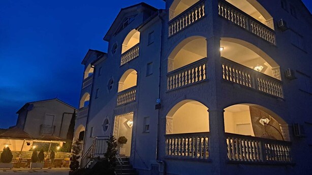 Ein mehrgeschossiges Gebäude mit Balkonen und Rundbogenfenstern, vermutlich ein Hotel oder Wohnhaus.