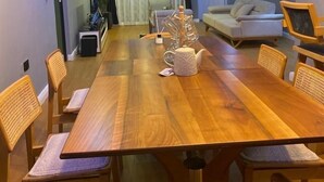A modern dining area with a wooden table, chairs, and a decorative teapot. - 3 Bedroom En-Suite, Wi-Fi, Secured, 24/7 Power (Lagos)
