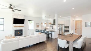 A modern kitchen with a central island, white cabinetry, and stainless steel appliances. - Prime Village Access | Walkable (Winter Park)
