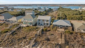 Un quartier résidentiel situé sur la côte, avec des maisons, une plage et une vue sur l’océan.