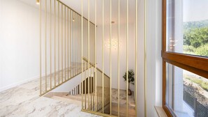 A modern interior with a marble staircase, a view through a large window, and a minimalist design. - Villa Veluno with Pool (Kaštel Lukšić)