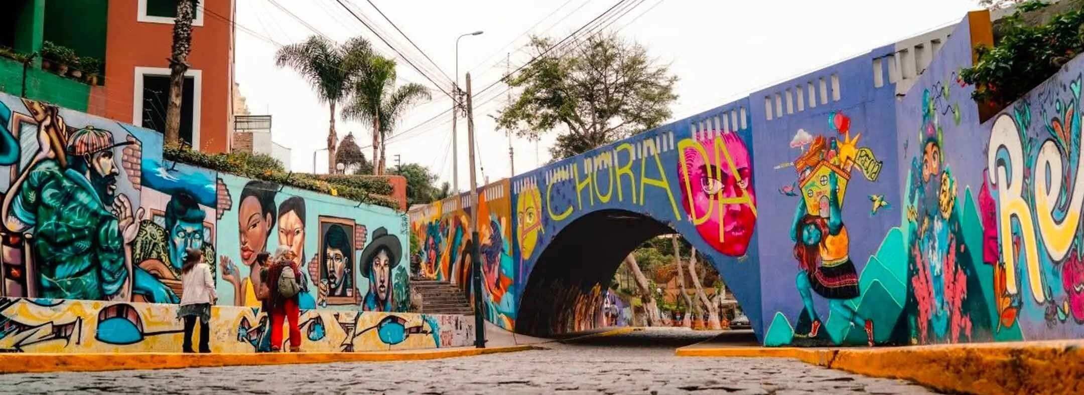 Une rue animée, aux couleurs vives, avec un pont et des peintures murales.