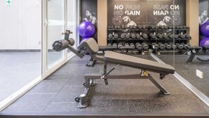 A gym with exercise equipment, a wall with motivational text, and a mirror reflecting the equipment. - Sight 1707 · Ocean View 2BR Stylish Apt • Pool, Gym & Parking (Lima)