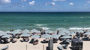 Una playa con hileras de sombrillas a rayas y sillas de descanso.