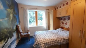 A bedroom with a bed, a chair, a window, and a wardrobe. - A 2 bed flat in clentral Dumfries, excellent walkability to all amenities. (Dumfries)