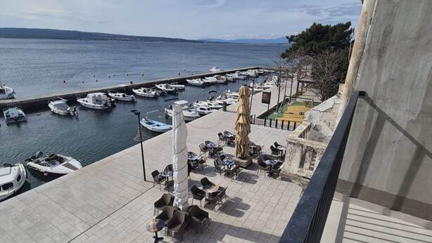 A marina with boats docked, outdoor seating, and a view of the sea. - Apartments Rivijera 2 (Crikvenica)