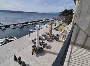 Un port de plaisance avec des bateaux amarrés, des tables à l’extérieur et une vue sur la mer.