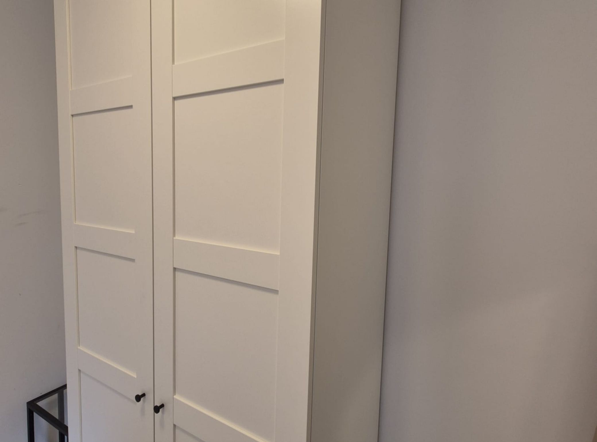 Una porta bianca dal design semplice con una maniglia.
