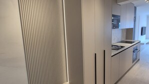 A modern kitchen with a sleek design, featuring a built-in oven, a microwave, and a stainless steel sink. - Apartments Rivijera 2 (Crikvenica)