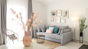 A modern living room with a grey sofa, a round coffee table, a wicker chair, a vase with branches, and a floor lamp. - Cozy apartment in Cilipi with WiFi (Cilipi)