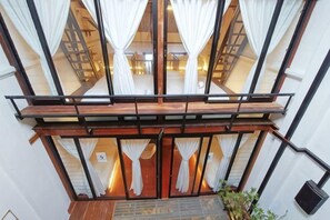 Un escalier avec une rampe en bois et des rideaux blancs.