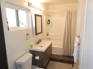 Ein Badezimmer mit Toilette, Waschbecken, Spiegel und Dusche.