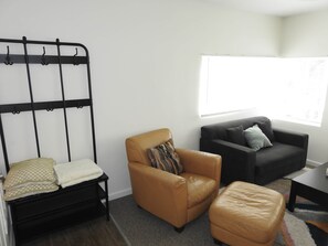 Ein Zimmer mit einem Bett, einem Sofa, einem Sessel und einem Fenster.