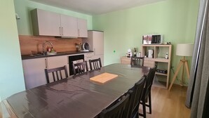 Cocina compacta con comedor, microondas y lámpara en un estante.