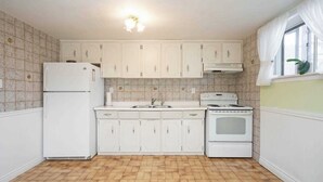 A kitchen with white cabinets, a refrigerator, a stove, and a sink. - Spacious 1 bedroom apartment, excellent location, separate entrance,safe & clean (Toronto)