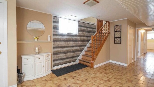 A spacious hallway with a wooden staircase, a white console, and a mirror. - Spacious 1 bedroom apartment, excellent location, separate entrance,safe & clean (Toronto)