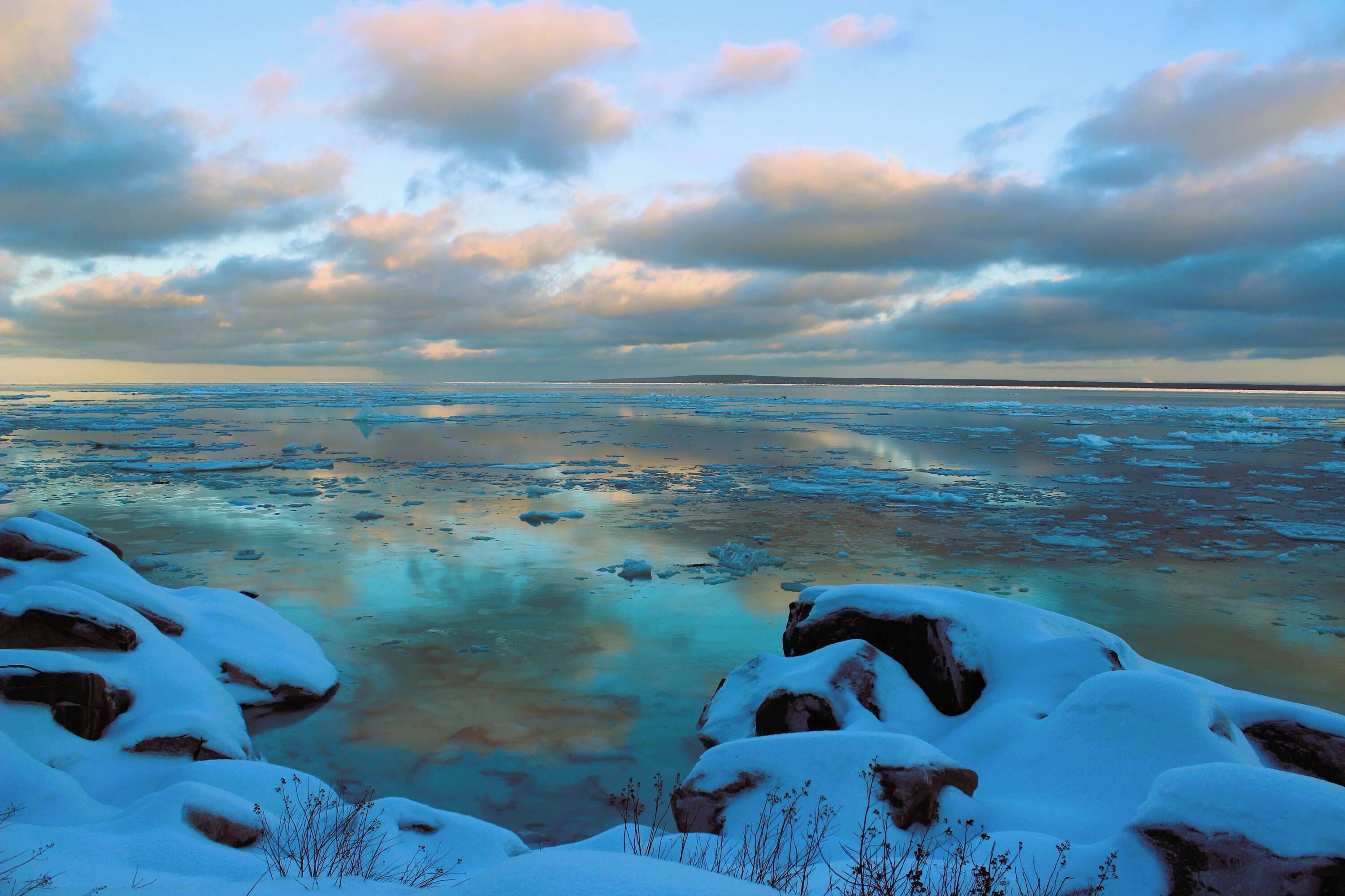 Un paysage hivernal, avec des rochers recouverts de neige et un horizon lointain.